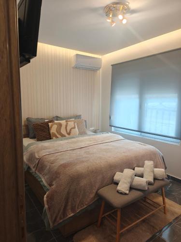 a bedroom with a large bed with two towels on a chair at Neria 1 in Alexandroupoli