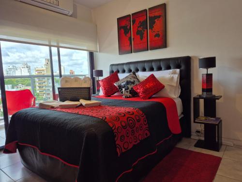 a bedroom with a large bed with red pillows at Confort Platense Centro Zona Catedral in La Plata