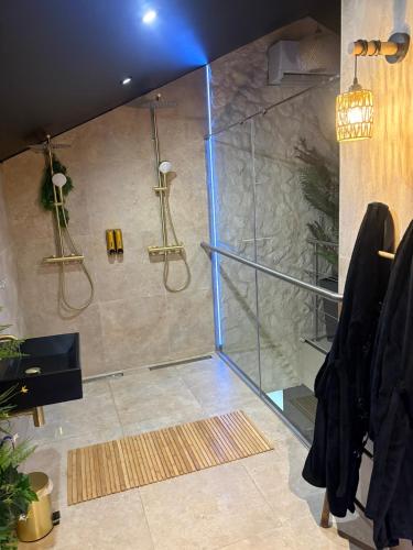 a shower with a glass door in a bathroom at AMORE suite de luxe & spa in Laplume