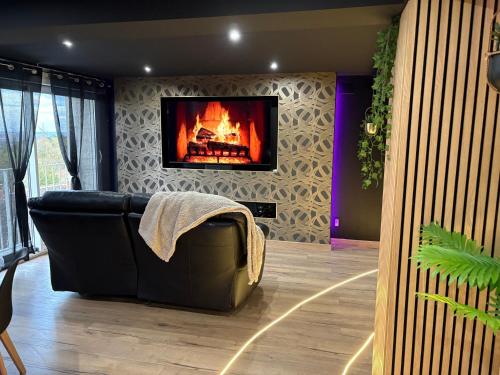a living room with a couch and a fireplace at AMORE suite de luxe & spa in Laplume