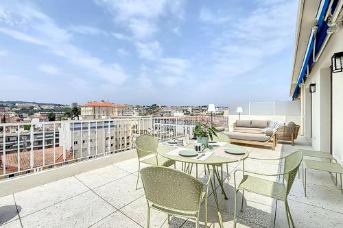 a balcony with a table and chairs and a couch at Sea View Terrace Penthouse Garage Walk to the Palais in Cannes