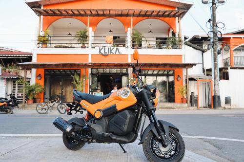 an orange motorcycle parked in front of a building at Klika Bocas del Toro in Bocas Town