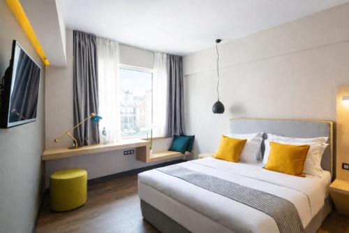 a bedroom with a large bed with yellow pillows at St. Bjur Suites in Athens