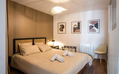 a bedroom with a bed with two towels on it at Le Vitrail - Climatisation, Parking & Wifi à 150m de la Cathédrale in Rodez