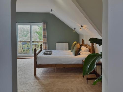 a bedroom with a bed and a large window at Lamack Vale House, Tenby, 5 Bedrooms with Private Heated Indoor Swimming Pool & Parking in Tenby