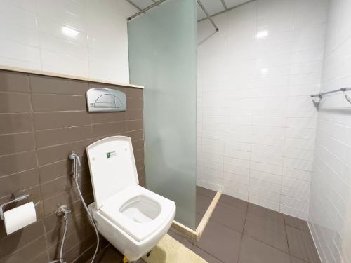 a bathroom with a white toilet in a stall at Charming Hideaway Studio with Cozy Views in Ras al Khaimah