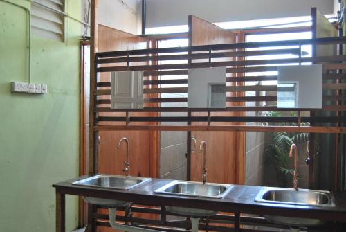 een rij van drie wastafels in een openbaar toilet bij Borneo Sweet Guesthouse in Kuching