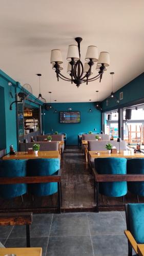 a dining room with tables and chairs and a chandelier at Station 44 Apartments in Bitola