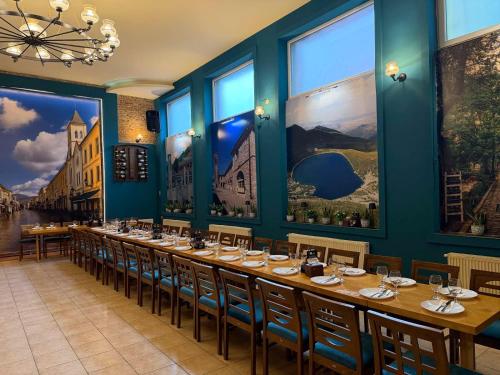 a long table in a restaurant with blue walls and windows at Station 44 Apartments in Bitola