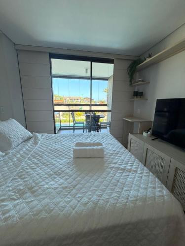 a bedroom with a large bed and a large window at Beach Class Summer Flat 4 pessoas in Porto De Galinhas