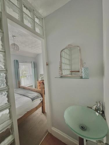 a bathroom with a green sink and a bedroom at Lamack Vale House, Tenby, 5 Bedrooms with Private Heated Indoor Swimming Pool & Parking in Tenby