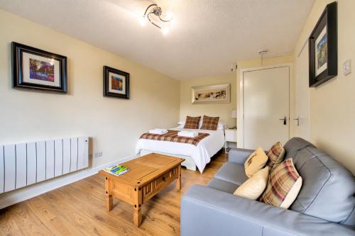 a living room with a couch and a bed at Stunning Studio Apartment Castle View in Edinburgh
