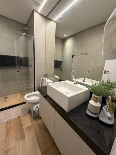 a bathroom with a white sink and a toilet at Beach Class Summer Flat 4 pessoas in Porto De Galinhas