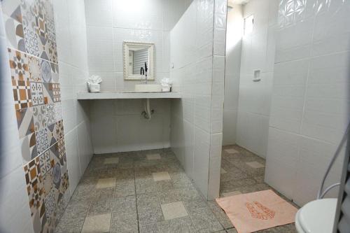 a white bathroom with a sink and a mirror at Pousada Marajoara- Hotel Fazenda-Turismo de Aventura in Soure
