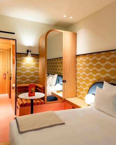 a hotel room with a bed and a mirror at Artcore Hotel Porto in Porto