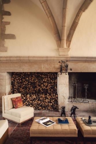 a living room with a pile of logs on a wall at Les Sources de Vougeot in Vougeot
