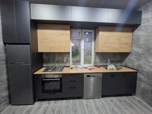 a kitchen with stainless steel appliances and wooden cabinets at Guesthouse Toma in Gonio