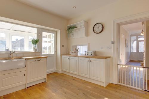 a kitchen with a sink and a clock on the wall at Fabulous Seaside Retreat in Hunstanton