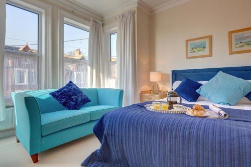 a blue bed with a blue couch in a room at Fabulous Seaside Retreat in Hunstanton