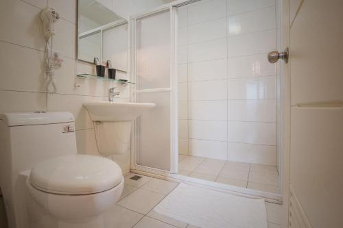 a white bathroom with a toilet and a shower at Tony's house in Jiaoxi