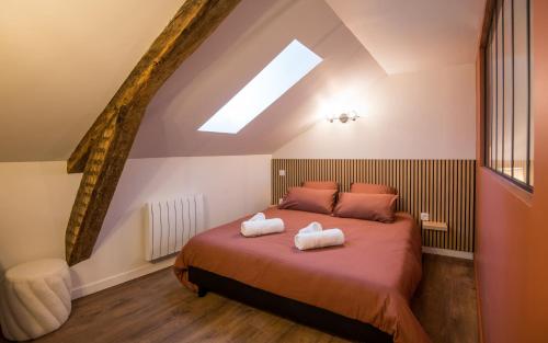 a bedroom with a bed with two towels on it at La Nef - Climatisation, Parking & Wifi à 150m de la Cathédrale in Rodez