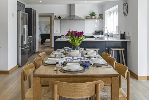 a dining room with a table and chairs in a kitchen at Cedar Barn in Chichester