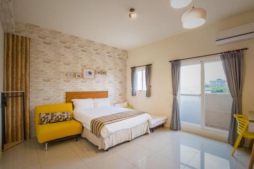 a bedroom with a bed and a yellow chair at Tony's house in Jiaoxi