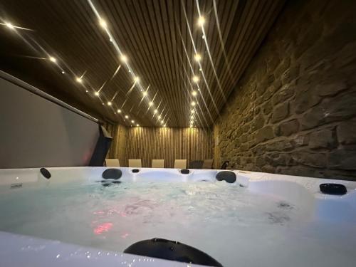 a bath tub in a room with a stone wall at Middlehead Cottages in Pickering