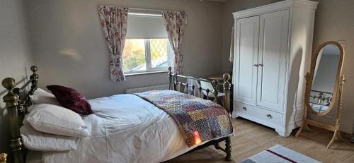 a bedroom with a bed with a dresser and a window at Downings View in Ballynaworthra