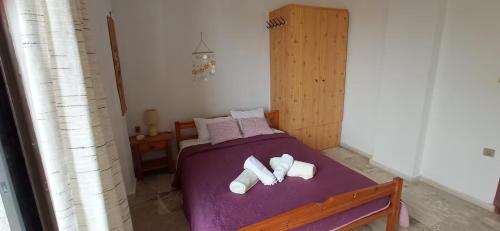 a bedroom with a purple bed with towels on it at Panoramic Seaview Apartments - Koroni in Koroni