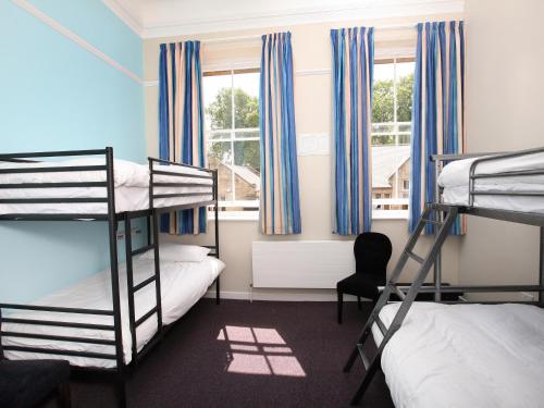 a bedroom with two bunk beds and a chair at YHA Alnwick - Partner in Alnwick