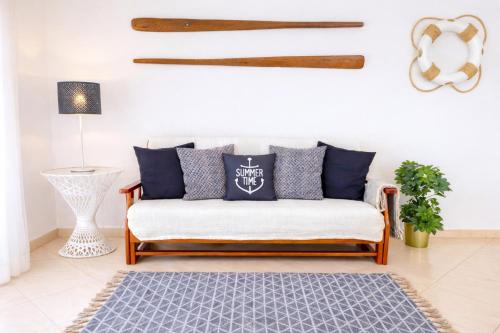 a living room with a couch with blue pillows at Avenue Apartment - Family-friendly T2 - Estacionamento Privado in Quarteira