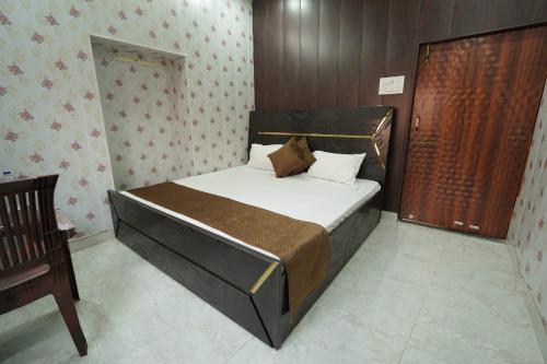 a bedroom with a large bed with a wooden headboard at Shiv Kothi Home Stay in Varanasi