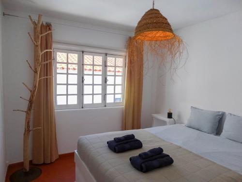 a bedroom with a bed with two towels on it at Casa Nela in Odeceixe
