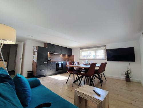 a living room with a blue couch and a table at FeWo Heimathafen in Bodman-Ludwigshafen