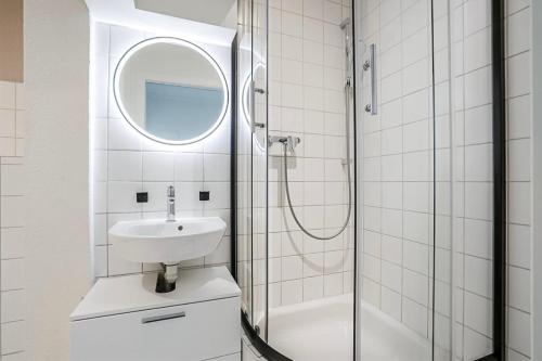 a bathroom with a sink and a shower with a mirror at Oak Suite · District 4 in Zurich