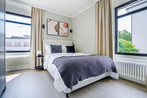 a bedroom with a bed and a large window at Oak Suite · District 4 in Zurich