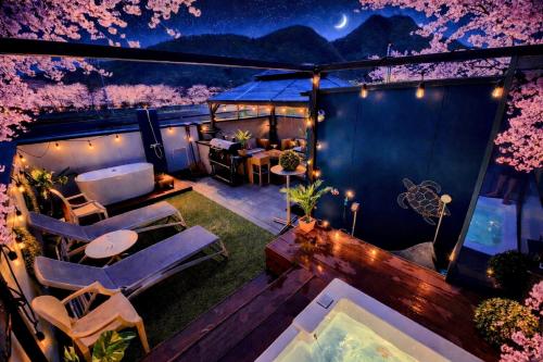 a balcony with chairs and a table and trees at Vacanza gifu sauna villa in Gifu