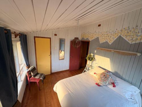 a bedroom with a white bed in a room at Refugio Urbano Melipulli in Puerto Montt