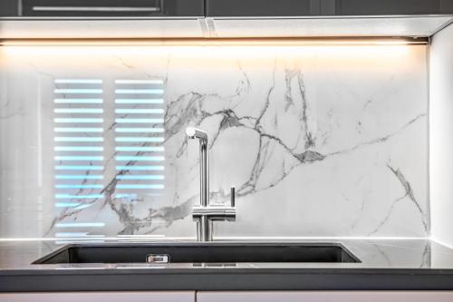 a kitchen sink with a marble counter top at ICONIC LEGACY Suite seafront in Thessaloniki