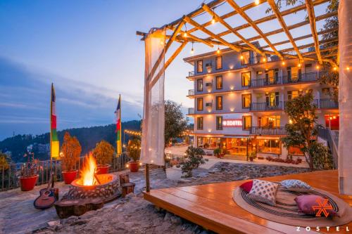 a hotel with a fire pit in front of a building at Zostel Dharamkot, Bhagsu in McLeod Ganj