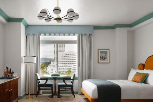 a bedroom with a bed and a table and a window at The Georgian, in The Unbound Collection by Hyatt in Santa Monica