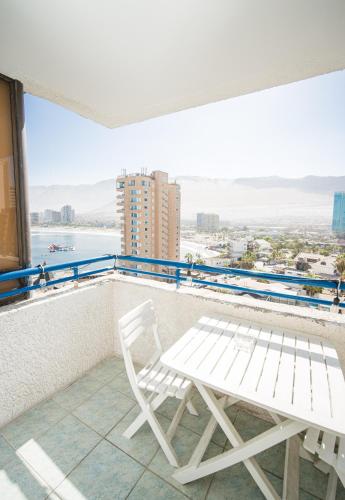 a white chair and a table on a balcony at Edificio Royal Marine in Iquique