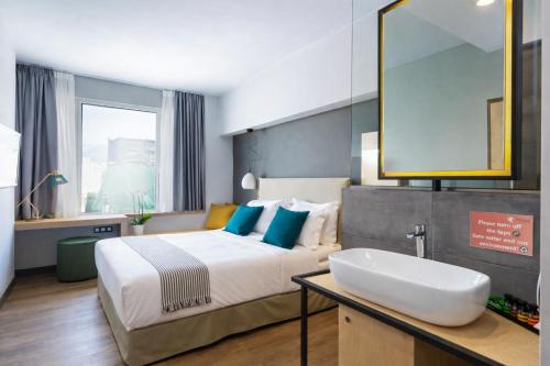 a bedroom with a bed with a sink and a mirror at St. Bjur Suites in Athens