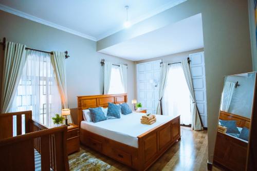 a bedroom with a large bed with blue pillows at Tunji Homestay in Arusha