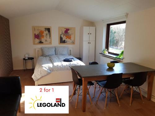 a bedroom with a bed and a table and chairs at Central Apartment in Billund - 500 m from LegoHouse in Billund