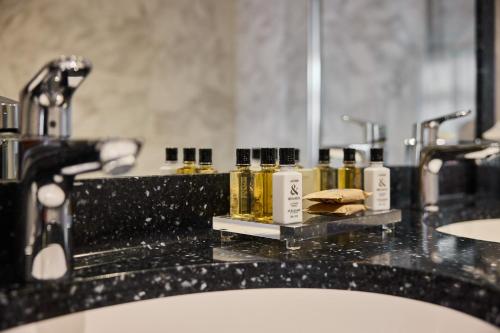 a bathroom counter with several bottles of oils on it at Aragon House in Bruges