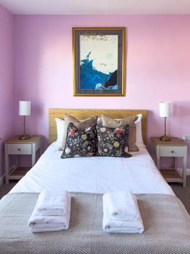 a bedroom with a large white bed with two lamps at Camden Rooms in London