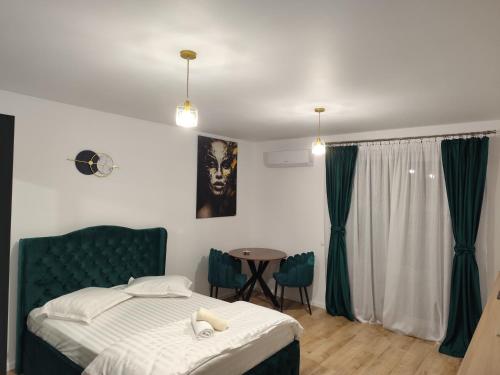a bedroom with a bed and a table with chairs at Vivien Residence 2 in Baia Mare