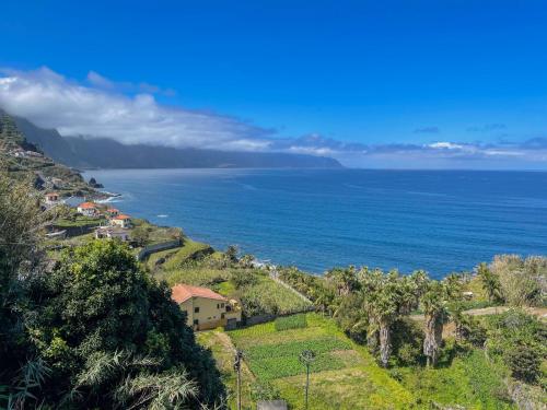 a house on a hill next to the ocean at Casa Do Pico in São Vicente